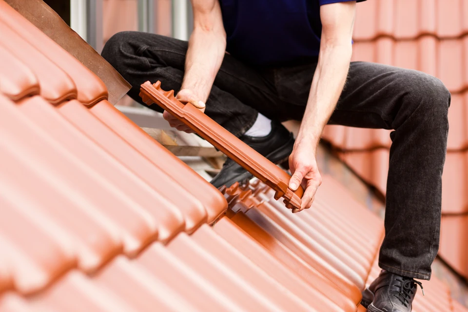 Couvreur professionnel installant des tuiles sur toiture en pente