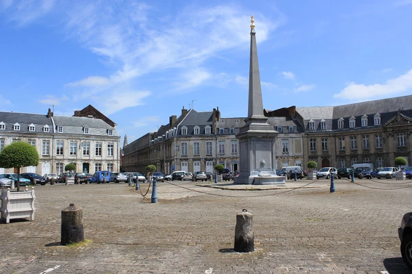 Photographie d'une perspective urbaine de la ville d'Arras montrant un ensemble de b&acirc;timents r&eacute;sidentiels ou patrimoniaux typiques de l'architecture des Hauts-de-France avec des toitures en ardoise, zinc ou cuivre visibles et bien d&eacute;taill&eacute;es. La photo doit &ecirc;tre prise en lumi&egrave;re naturelle de jour, capturer l'environnement urbain caract&eacute;ristique d'Arras, sans personne visible, et mettre en &eacute;vidence la qualit&eacute; et la diversit&eacute; des couvertures pour illustrer le savoir-faire en couverture artisanale sur ce territoire.