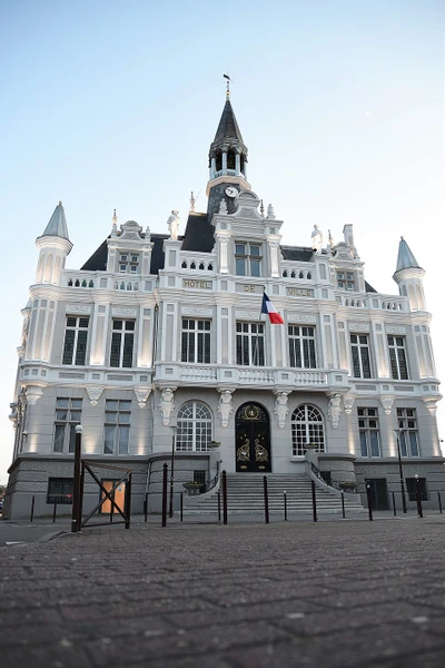 Photographie d'une toiture en ardoise d'une maison traditionnelle dans un contexte de b&acirc;timent ancien ou patrimonial des Hauts-de-France, prise en vue g&eacute;n&eacute;rale montrant la qualit&eacute; de la couverture et les finitions. L'image doit pr&eacute;senter clairement les mat&eacute;riaux de couverture noble (ardoise) et la pr&eacute;cision du travail artisanal, sans personne visible, dans une lumi&egrave;re naturelle en conditions de jour.