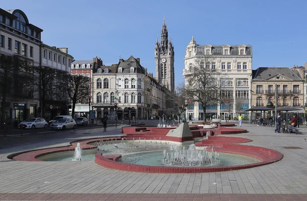 Photographie d'une rue typique de Douai avec des b&acirc;timents r&eacute;sidentiels ou commerciaux du nord de la France (architecture traditionnelle des Hauts-de-France), montrant clairement une ou plusieurs toitures en ardoise ou en mat&eacute;riaux nobles (zinc, cuivre) depuis une perspective qui situe g&eacute;ographiquement la localit&eacute;. La photo doit &ecirc;tre prise en lumi&egrave;re naturelle de jour, sans personne visible, et mettre en &eacute;vidence la qualit&eacute; des couvertures et finitions pour d&eacute;montrer la pertinence de l'intervention d'un couvreur artisanal sur ce territoire.