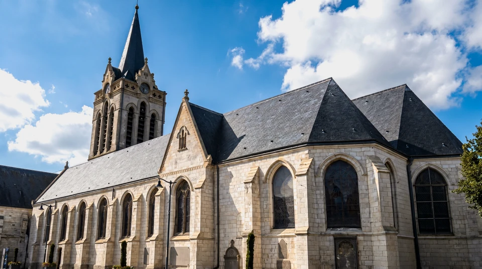Artisan en vêtements de travail installe une fenêtre de toit dans les combles d'une habitation
